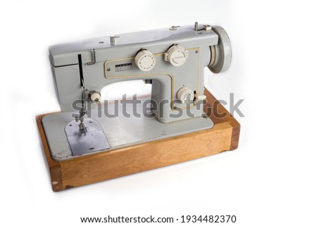 Old electric sewing machine on a white
