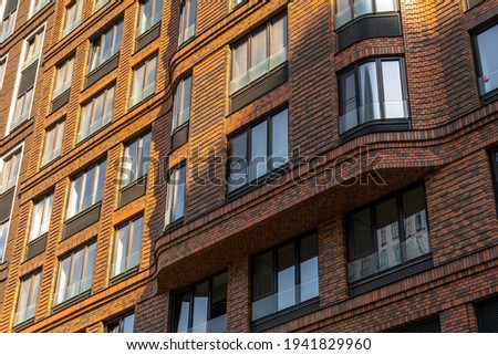Bottom up view on  new modern residential buildings made of red and brown brick in the sunset light. Medium-rise residential building.
