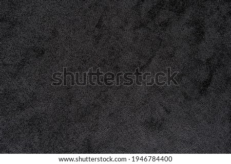 Structure of black fabric as pattern backdrop. Dark grey background from textile material with wicker texture. Top view.