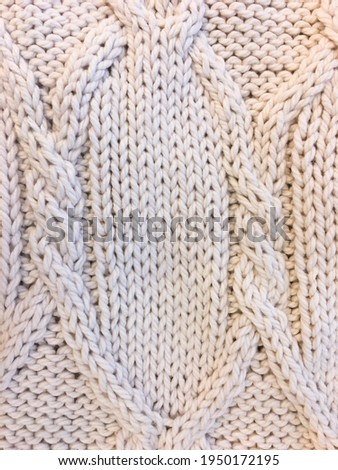 Background of white warm knitted sweater textile