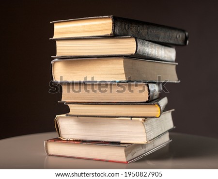 Pile or stack of books, literature, textbooks on dark background.