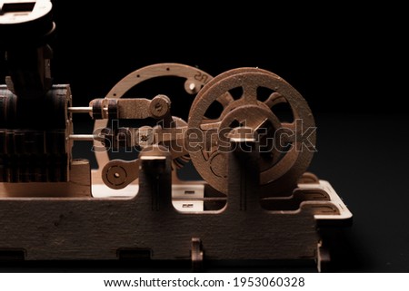 Model engine made of wood and plywood on a black background