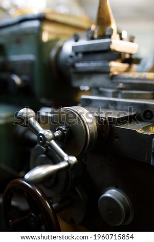 Lathe close-up, metal with a blurred background. Old locksmith lathe, components and tools.