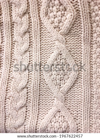 Background of white warm knitted sweater textile


