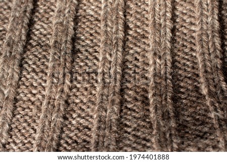 Close-up of the collar of a large knitted jumper. With a rib stitch  pattern. Heathered beige colour.
