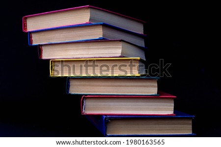 Colorful books are stacked in a stack in the form of a ladder. Ladder of Knowledge