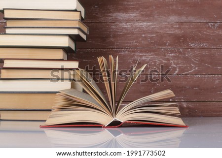Science and education -  Open book on a group books and wooden background. With reflection