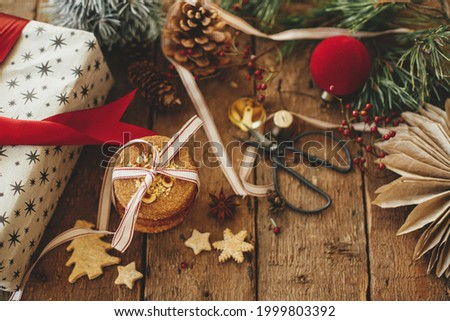 Christmas cookies, gift, festive decorations on rustic wooden table. Atmospheric stylish christmas composition. Xmas present, healthy oatmeal cookies, ornaments. Holiday moody image. Merry Christmas