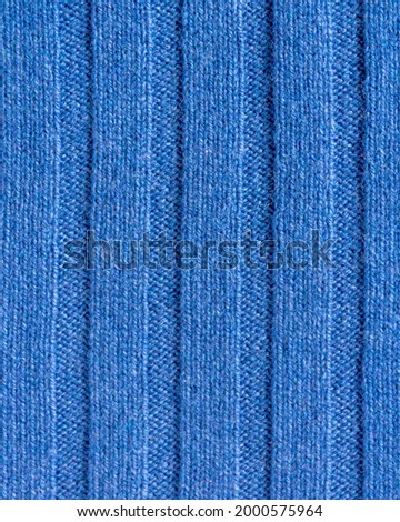 Slow fashion background. Texture of expensive, exclusive knitwear made of cashmere, wool and viscose. Natural, warm, cozy, knitted interior and costume fabric with vertical stripes for cold weather