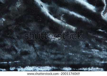 Shiny blue-black velvet. The texture of the fabric. Backgrounds