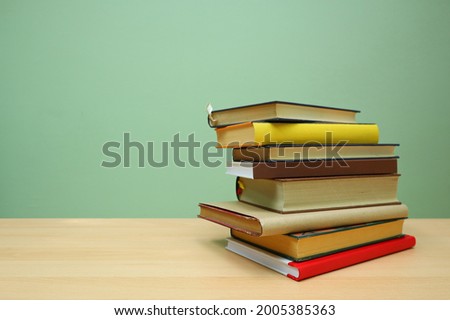Books on a table with a green background