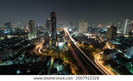 Time lapse shot of night life in the modern big city, lighted skyscraper, traffic, intersection, Bangkok, Thailand
