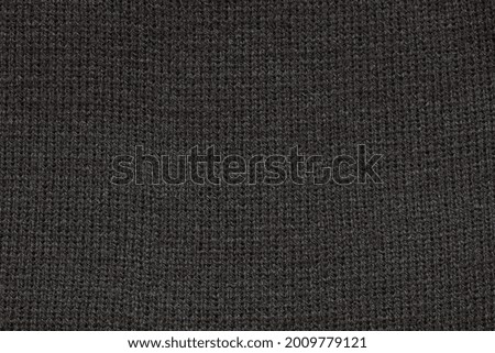 Black texture of the fabric of a winter hat. Fabric texture. 