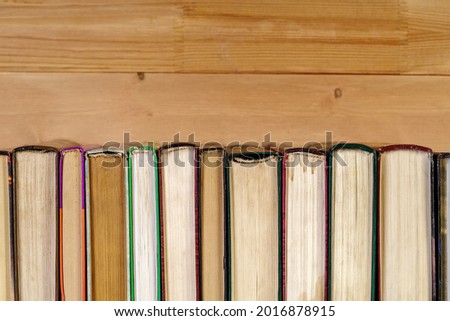 Stack of old books on a wooden shelf