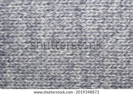 Close up photo of gray wool sweater texture as abstract background.
