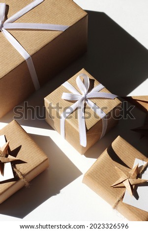 Festive Gift Boxes in Brown Kraft Paper Decorated with Ribbon Bow. Christmas Holidays.