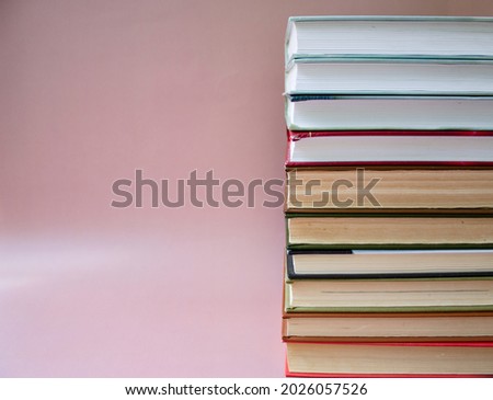 a stack of books, a pink background, a lot of book pages