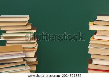 Many hardcover books near green chalkboard, space for text. Library material