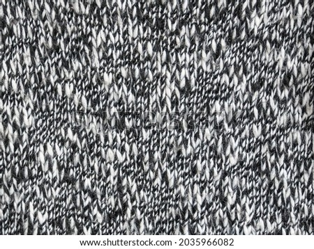 Close-up of the surface of a black and white acrylic and cotton jersey. Texture. Background.
