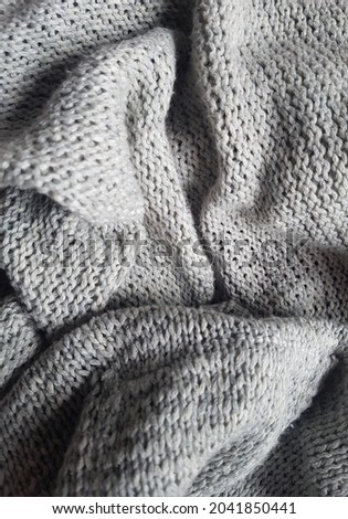 Scrounged up grey knitted jumper cardigan. Knitted fabric bundle.