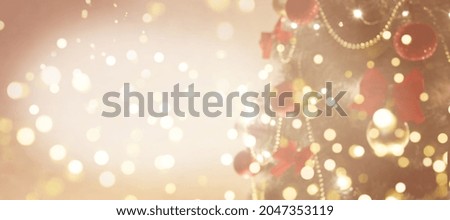 Defocused holiday background with christmas tree, balls and garlands. Beige and gold banner with copy space and bokeh.