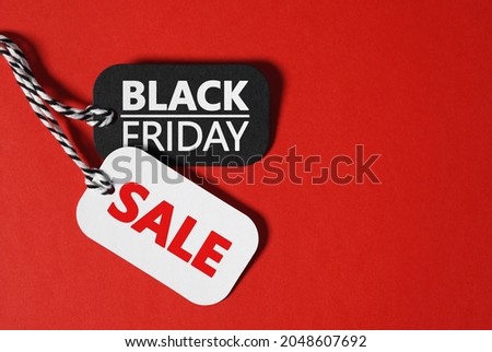 Black friday sale thanksgiving day and Christmas shopping concept with black friday and sale text on black and white paper price tags on red background banner with copy space.