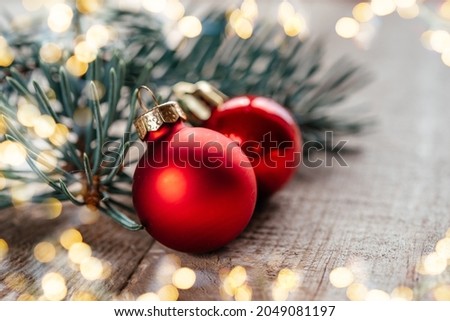 Red Christmas balls on wooden background with Christmas lights bokeh