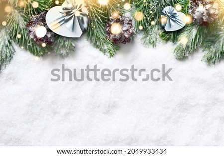 Christmas background, green pine branches, gift box on snow background and light. Creative composition with border and copy space, top view. New Year's, holiday, christmas, decoration.