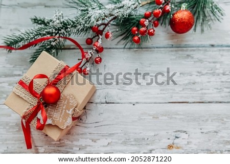 gift box and Christmas decorations on a wooden background with snowflakes.