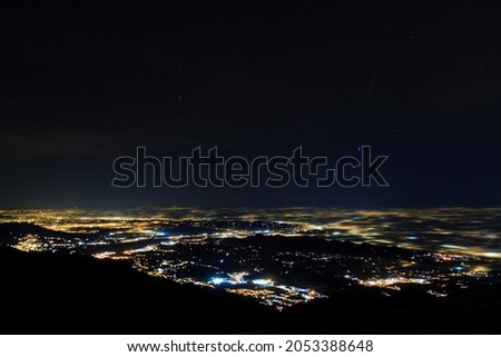 Plain illuminated partially covered by fog, soft lights.  Mount Grappa, Italian landscape