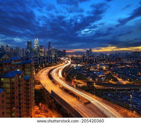 Light trail at busy highway with the view of Kuala Lumpur city