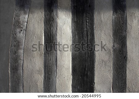 Background texture formed by a side-lit wall of an old half-timbered house in France.