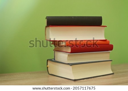 A pile of books on a green background