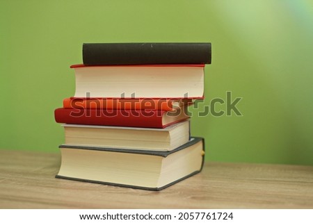 A pile of books on a green background
