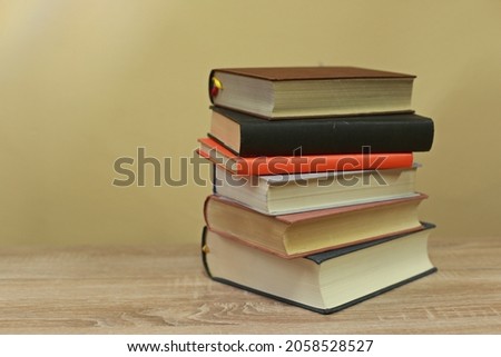 A pile of books on a yellow background