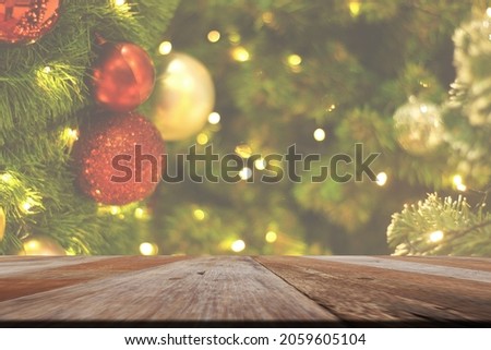 Empty table in front of christmas tree with decorations background. For product display montage