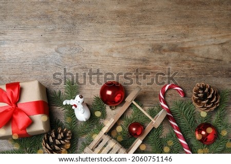 Christmas greeting card with space for text. Flat lay composition of fir tree branches and festive decor on wooden background