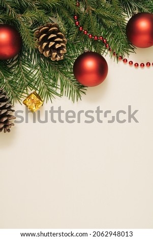 Branches of a Christmas tree, Christmas balls on a pastel beige background. Christmas composition. Minimal style. Flat layout, top view.