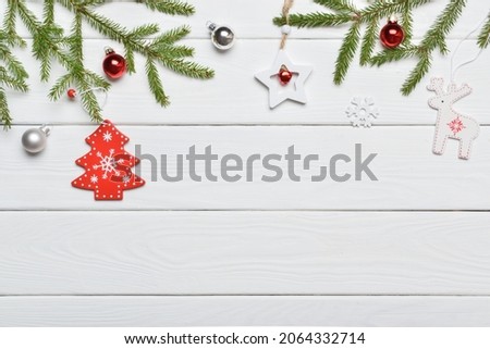 Festive background with a gift, glass Christmas balls and wooden toys on a white wooden table. A place to copy. A place to copy. Flat position, top view.