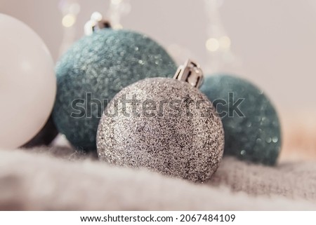 Christmas balls of blue and silver color on a gray sweater.