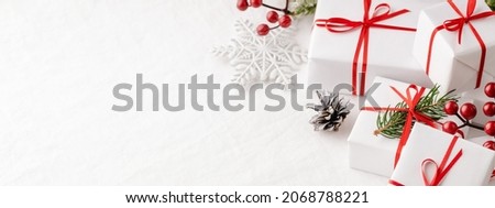 Banner with Christmas gift boxes on white tablecloth.