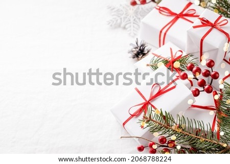 Christmas gift boxes with decorations on white tablecloth with copy space.