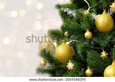 Fir, Christmas tree decorated with golden shiny ball present box and snowflex light on the pine branch with bokeh light background for Merry Christmas season greeting.