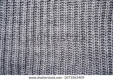 the texture of a gray knitted woolen jacket, sweater.