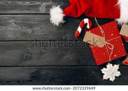 Santa Claus cap and Christmas gift on wooden background top view