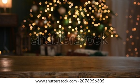 Christmas background. Empty wooden table on the background of the Christmas tree and New Year's bokeh.Ready for product montage