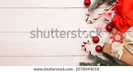  Christmas or New Year Decoration, background. Ornament with gift boxes, red Christmas baubles, fir branches on an old white wooden table with copy space.                                