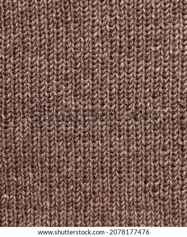 Knit pattern. Close-up of knitted wool texture. Brown pattern knit as background.