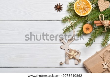Eco-composition of spruce branches and wooden ornaments and a box packed in kraft paper. Flat layout, top view. copy space