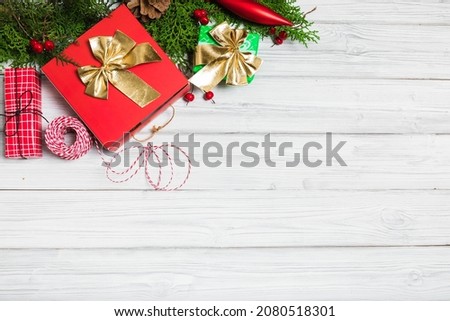 Christmas branches, gift boxes and red berries on white wooden table. Christmas background. Flat lay. top view with copy space